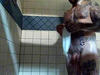 Scène de douche hardcore avec un homme blanc tatoué et sa grosse bite