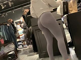 Een sexy blanke vrouw in leggings pronkt met haar perfecte billen