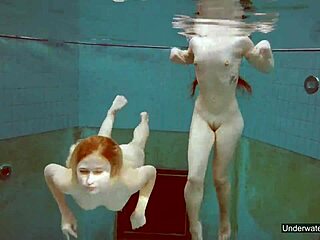 2人の美しい女の子がプールで泳ぎ、体を弄ぶ